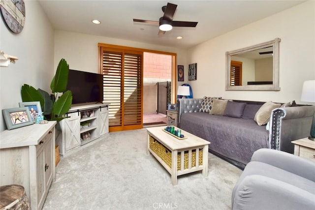 living area featuring recessed lighting, light colored carpet, and a ceiling fan