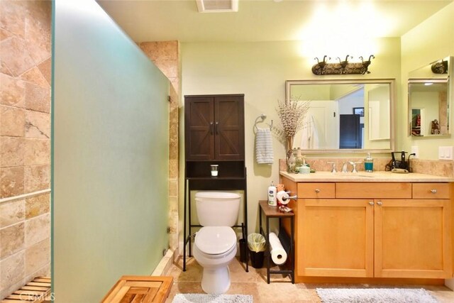 full bath with tile patterned flooring, toilet, vanity, and a walk in shower