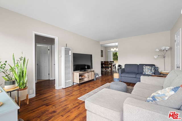 living room with a chandelier and dark wood-type flooring