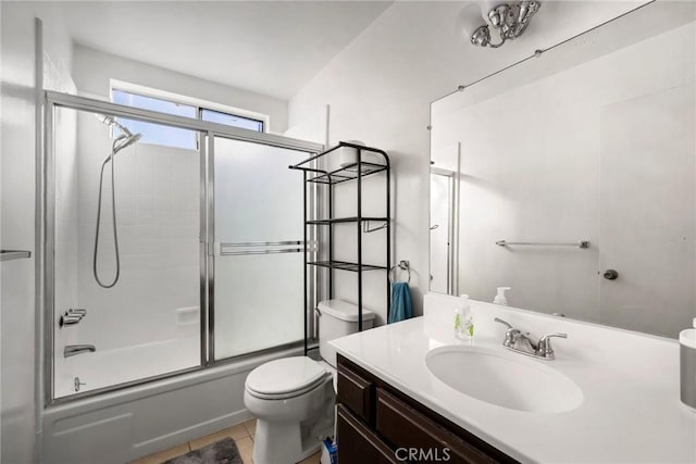 full bathroom with shower / bath combination with glass door, tile patterned floors, vanity, and toilet