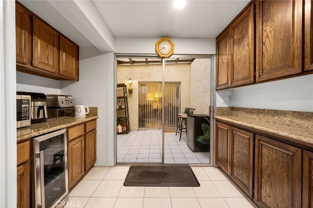 kitchen with light tile patterned floors, stone countertops, and wine cooler