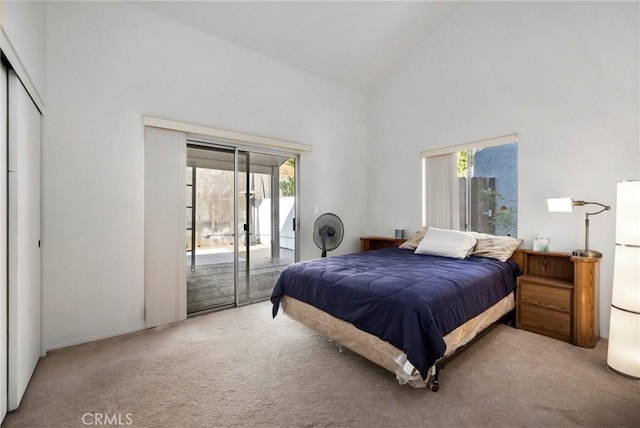 bedroom with high vaulted ceiling, carpet floors, and access to outside