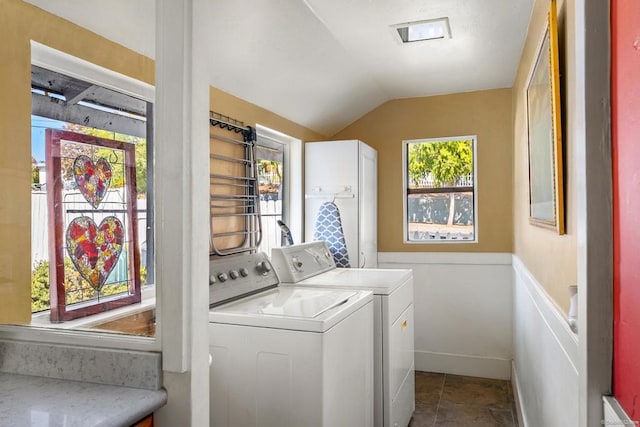 washroom featuring tile patterned flooring, washing machine and dryer, and a wealth of natural light