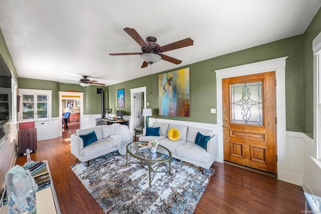 living room with ceiling fan and dark wood-type flooring