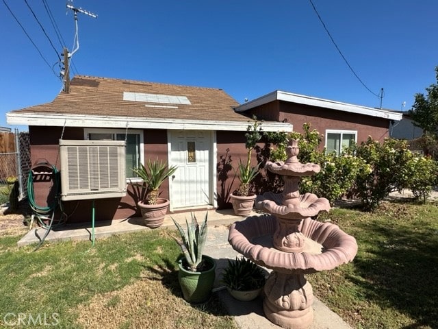 rear view of property featuring a yard and central AC