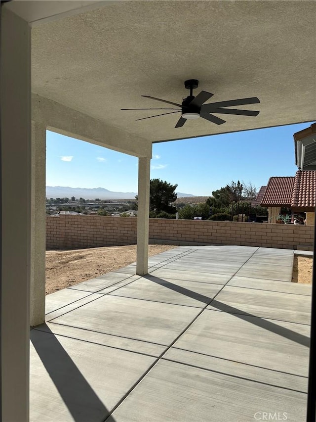 view of patio / terrace with ceiling fan and a mountain view