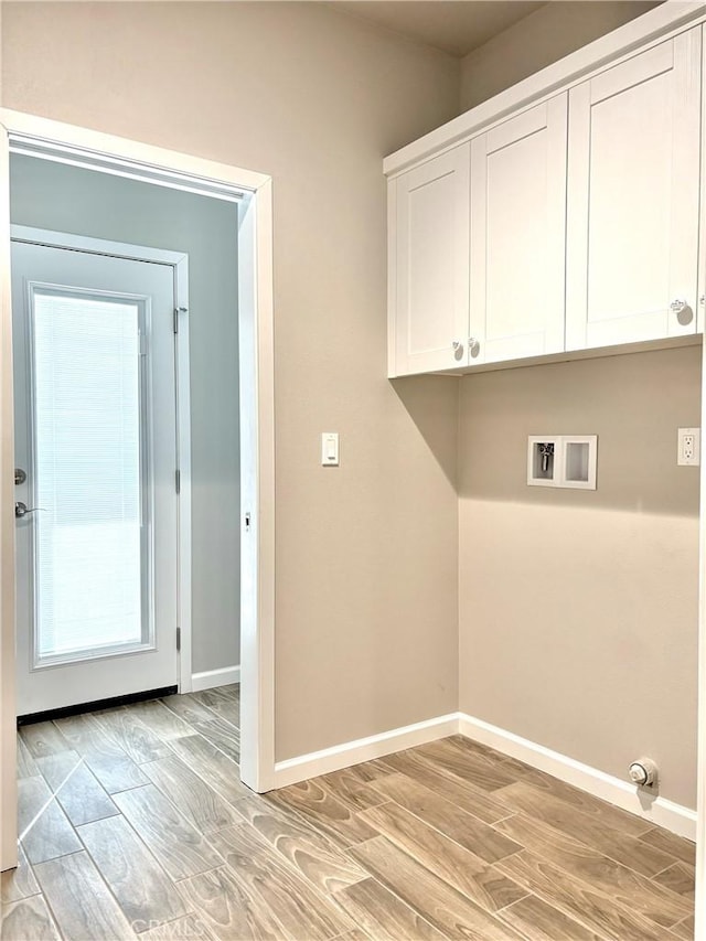 laundry room with cabinets, hookup for a washing machine, and light hardwood / wood-style flooring