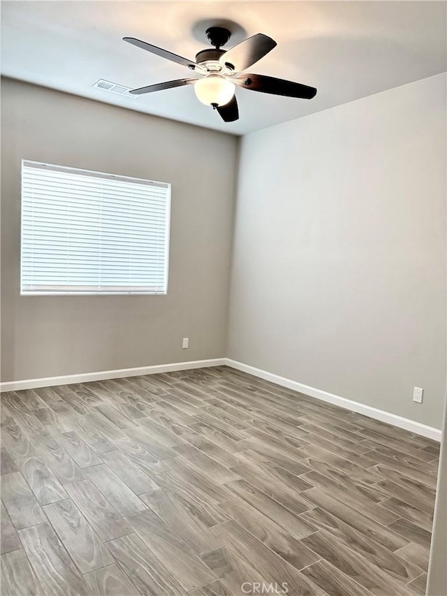 empty room with light hardwood / wood-style flooring, ceiling fan, and a healthy amount of sunlight