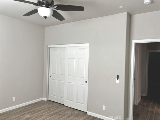 unfurnished bedroom with dark hardwood / wood-style flooring, ceiling fan, and a closet