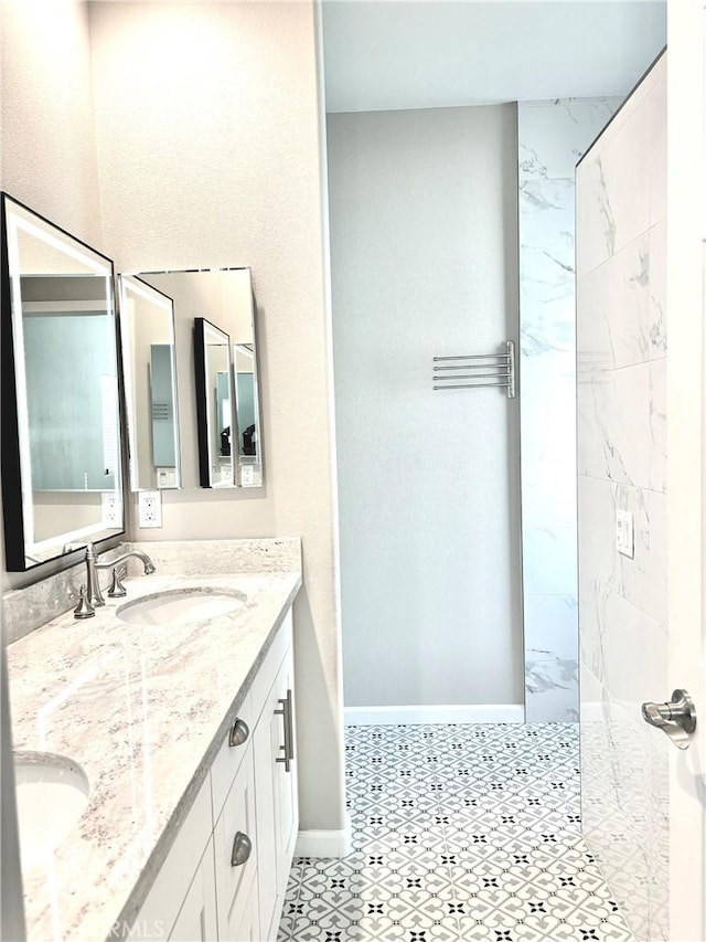 bathroom with a tile shower and vanity