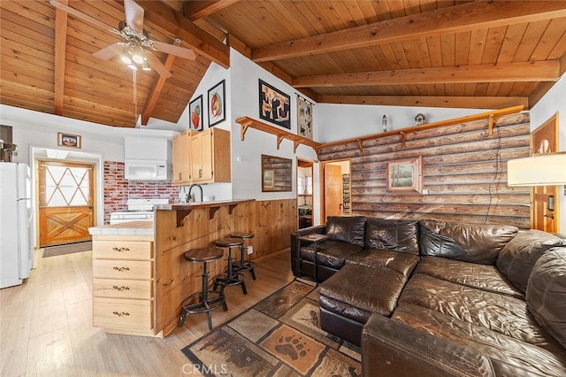 living room featuring light wood-type flooring, beamed ceiling, ceiling fan, high vaulted ceiling, and wooden ceiling