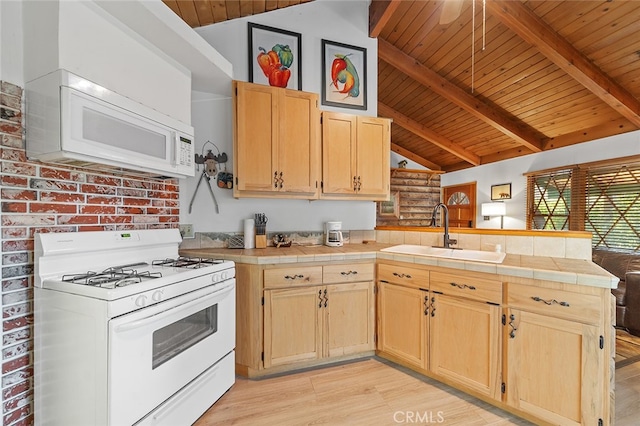 kitchen with white appliances, sink, light hardwood / wood-style floors, kitchen peninsula, and vaulted ceiling with beams