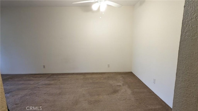 empty room with dark colored carpet and ceiling fan