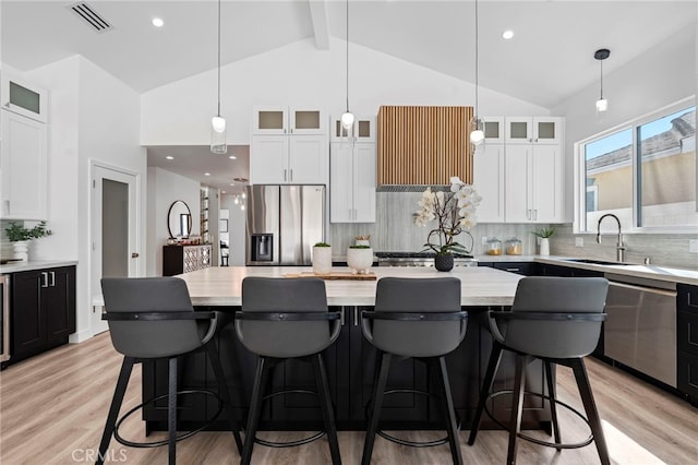 kitchen featuring appliances with stainless steel finishes, light hardwood / wood-style flooring, a kitchen island, and sink