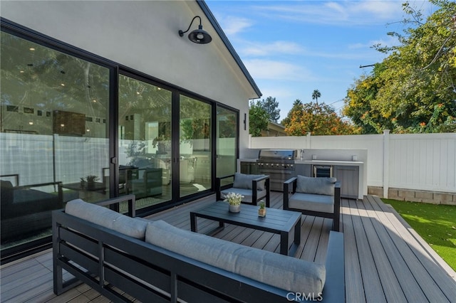 deck with outdoor lounge area, exterior kitchen, and grilling area