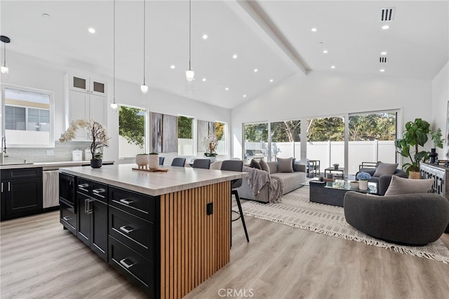 kitchen featuring pendant lighting, a kitchen breakfast bar, a kitchen island, and light wood-type flooring