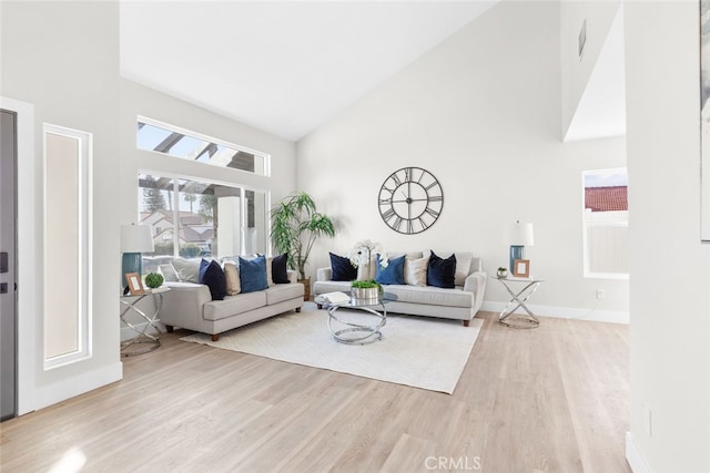 living room featuring light hardwood / wood-style floors and high vaulted ceiling