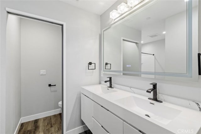 bathroom featuring hardwood / wood-style floors, vanity, and toilet