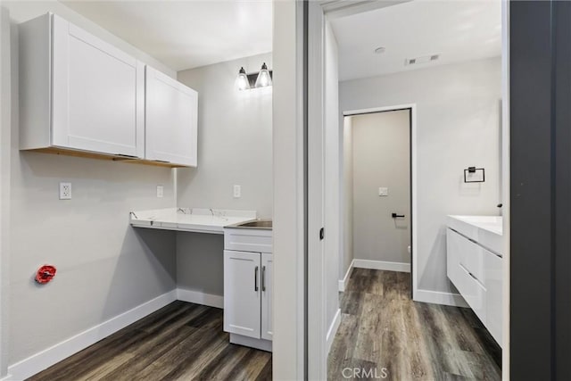 clothes washing area with dark wood-type flooring