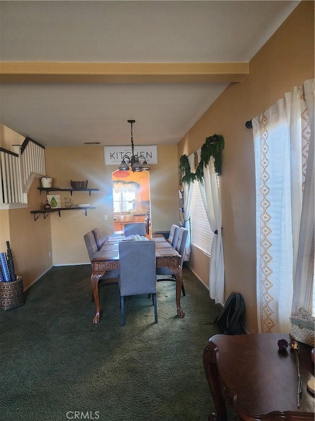 carpeted dining room with beamed ceiling and a chandelier