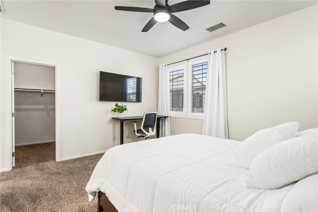 carpeted bedroom with a walk in closet, a closet, and ceiling fan