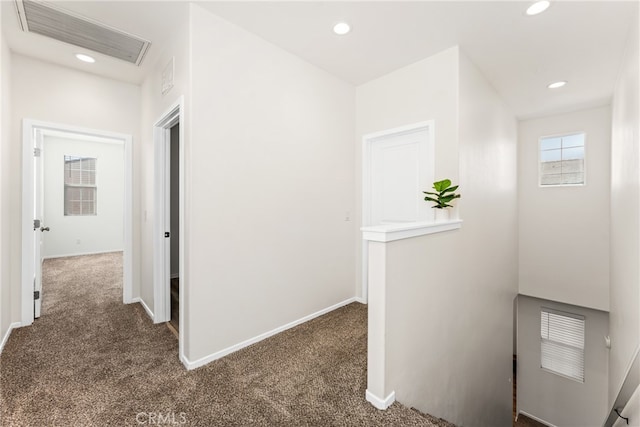 hall featuring dark colored carpet