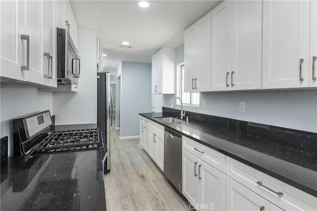 kitchen with light hardwood / wood-style flooring, stainless steel appliances, sink, and white cabinetry