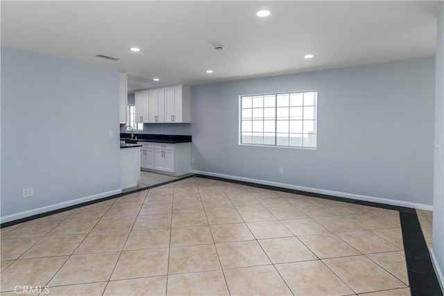 10125 Sharp Ave, Arleta, CA 91331 - kitchen with dark countertops, white cabinets, recessed lighting, baseboards, and light tile patterned floors