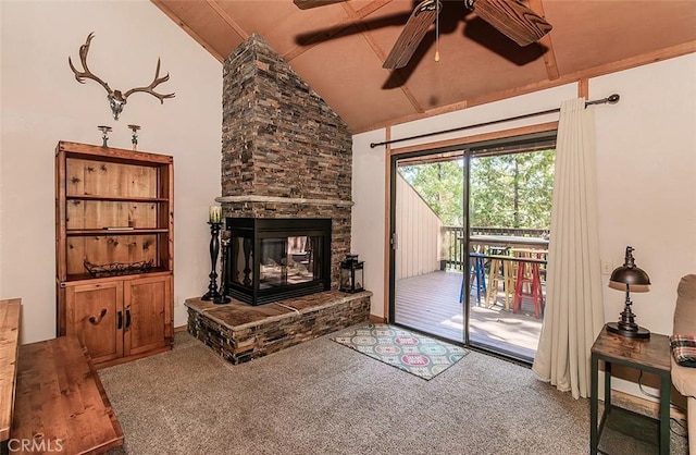 carpeted living room with a fireplace, vaulted ceiling, and ceiling fan