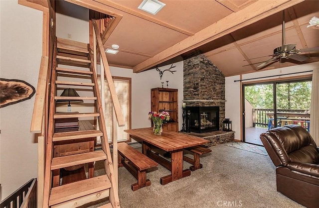 living room with carpet flooring, ceiling fan, a fireplace, and beam ceiling