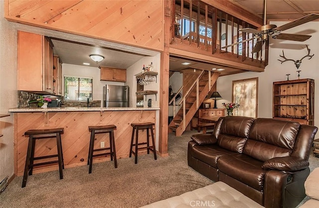 living room featuring ceiling fan, carpet floors, and sink