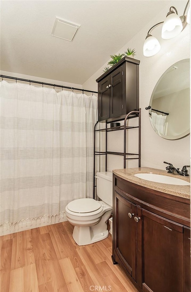 bathroom with hardwood / wood-style flooring, vanity, and toilet