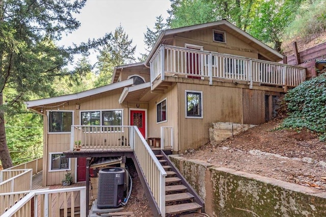 rear view of house with a wooden deck and cooling unit