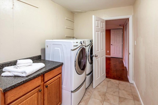 laundry area featuring cabinets, light tile patterned floors, and washing machine and dryer