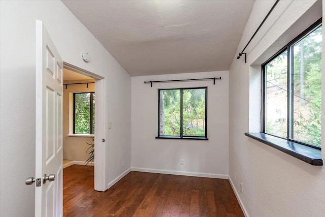 spare room featuring a textured ceiling and wood-type flooring