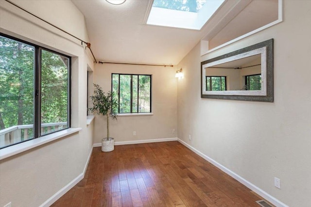 unfurnished room featuring hardwood / wood-style floors and lofted ceiling with skylight