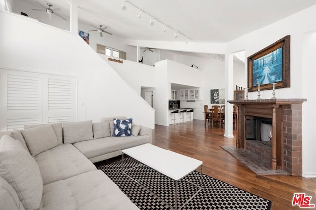 living room with track lighting, high vaulted ceiling, ceiling fan, and dark wood-type flooring