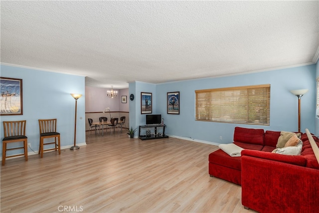 living room with a notable chandelier, light wood-type flooring, crown molding, and a textured ceiling