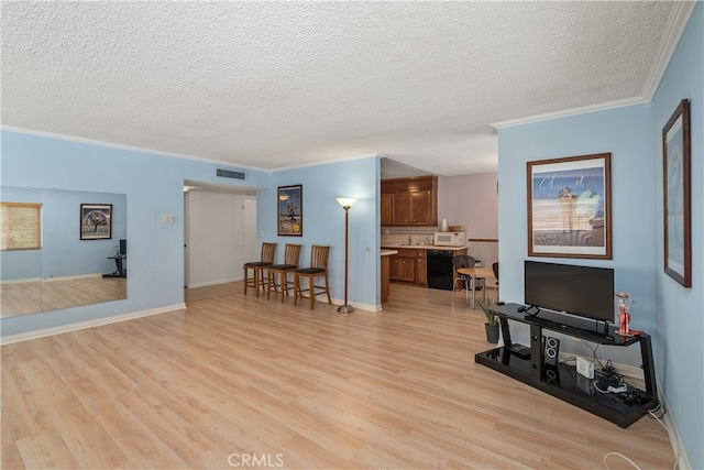 living room with ornamental molding, light hardwood / wood-style flooring, and a textured ceiling