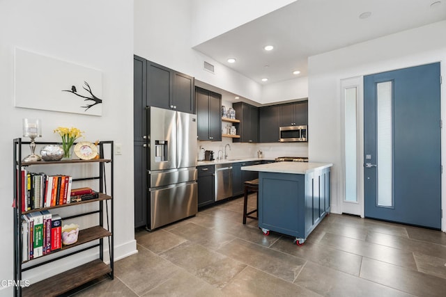 kitchen featuring stainless steel appliances, kitchen peninsula, a breakfast bar area, and sink