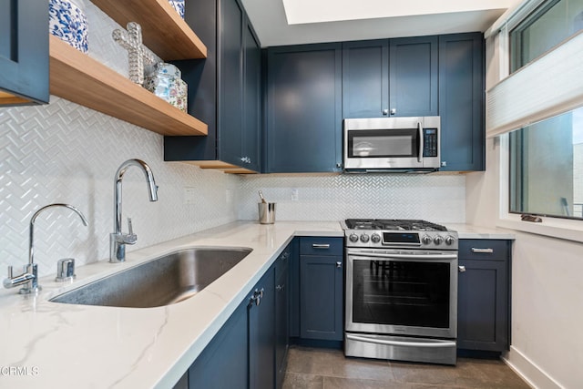 kitchen featuring light stone counters, stainless steel appliances, sink, and decorative backsplash