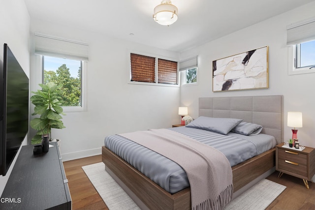 bedroom with dark wood-type flooring and multiple windows