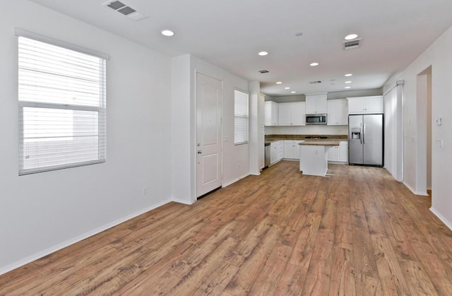 kitchen featuring white cabinetry, light hardwood / wood-style flooring, stainless steel appliances, and a kitchen island