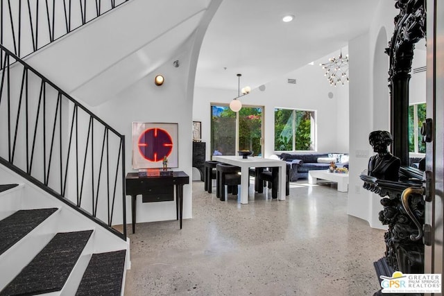 dining space featuring a notable chandelier and a high ceiling