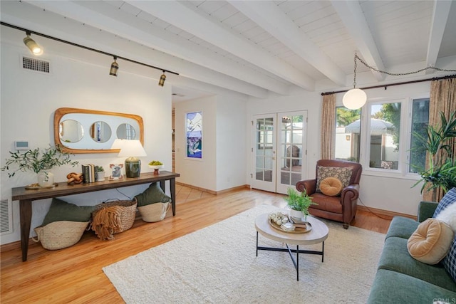 living room with french doors, beamed ceiling, hardwood / wood-style flooring, and track lighting