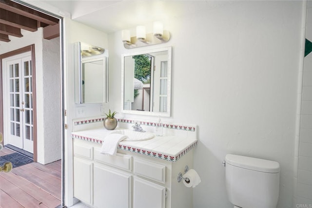 bathroom with vanity, toilet, and hardwood / wood-style flooring