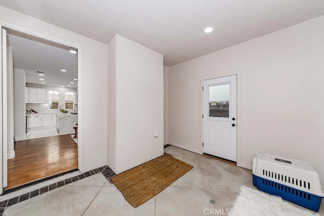 interior space featuring light tile patterned floors and a textured ceiling