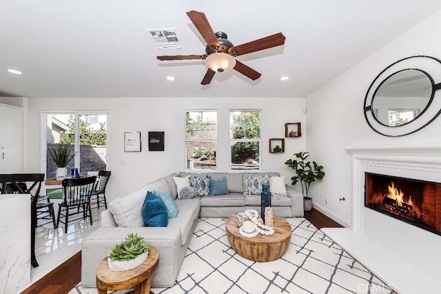 living room featuring a wealth of natural light, ceiling fan, and light wood-type flooring