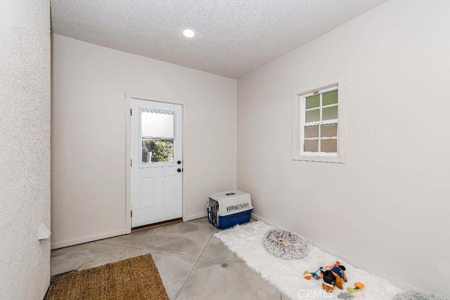 doorway to outside featuring a textured ceiling