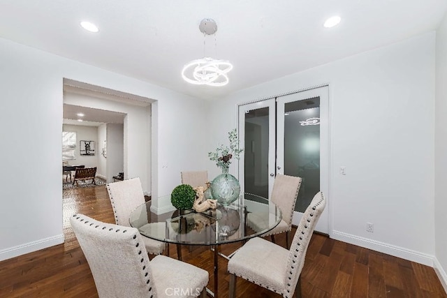 dining room with a chandelier, dark wood-type flooring, and french doors